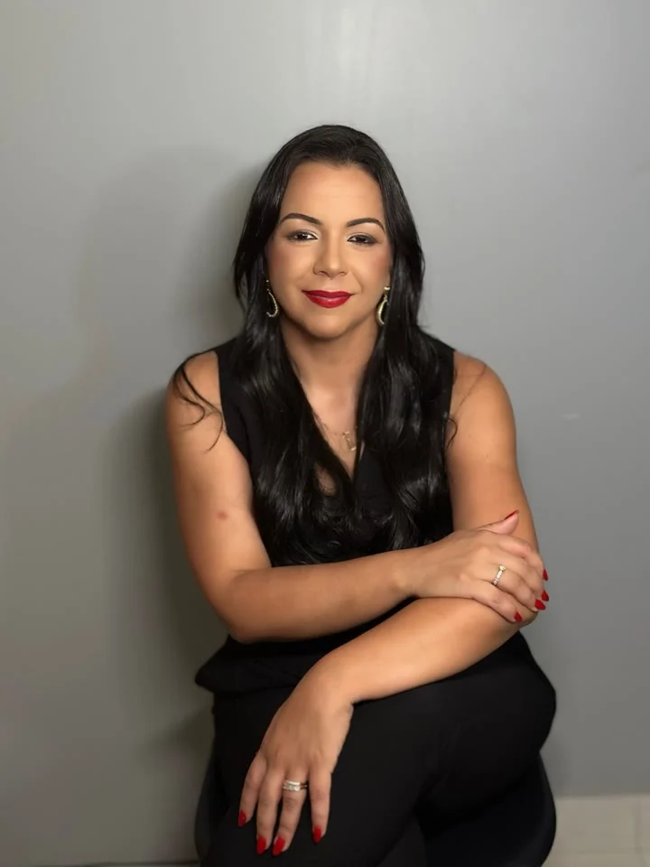 Grazielle de Paula Correa, advogada de família, sentada diante de uma parede cinza